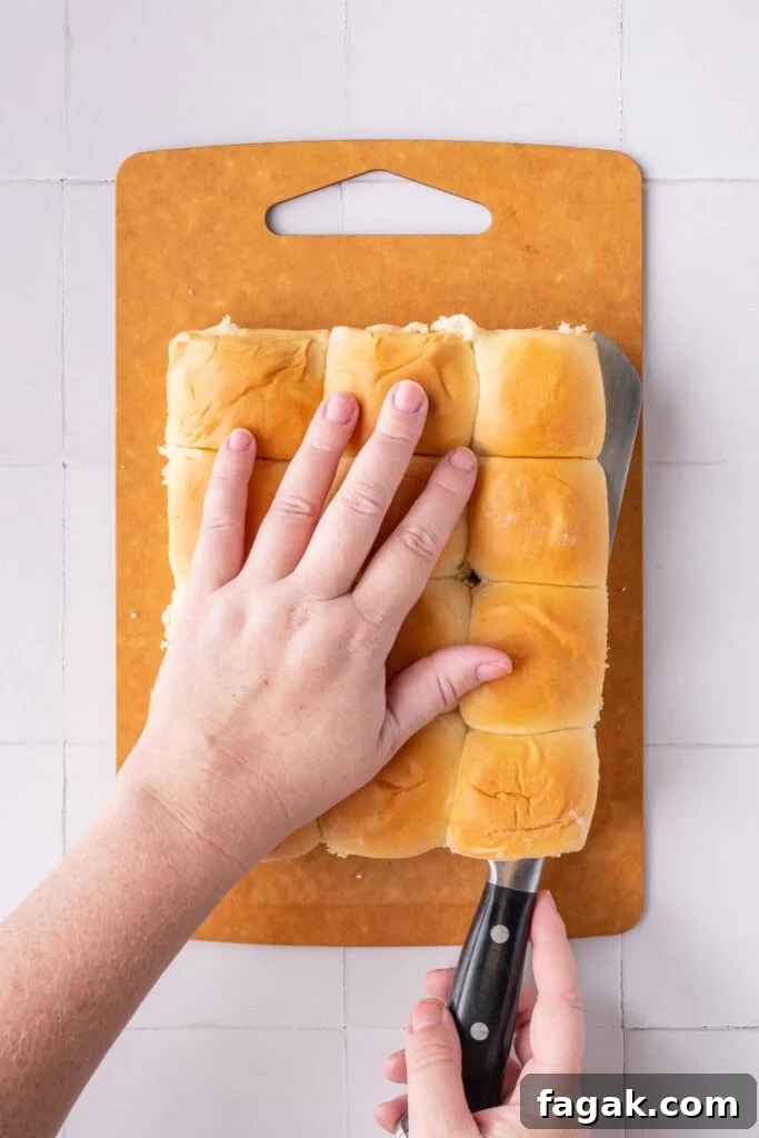 Slicing package of Hawaiian rolls in half.