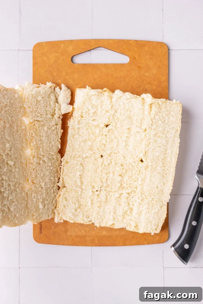 Lifting top half of Hawaiian rolls off the bottom half after slicing.