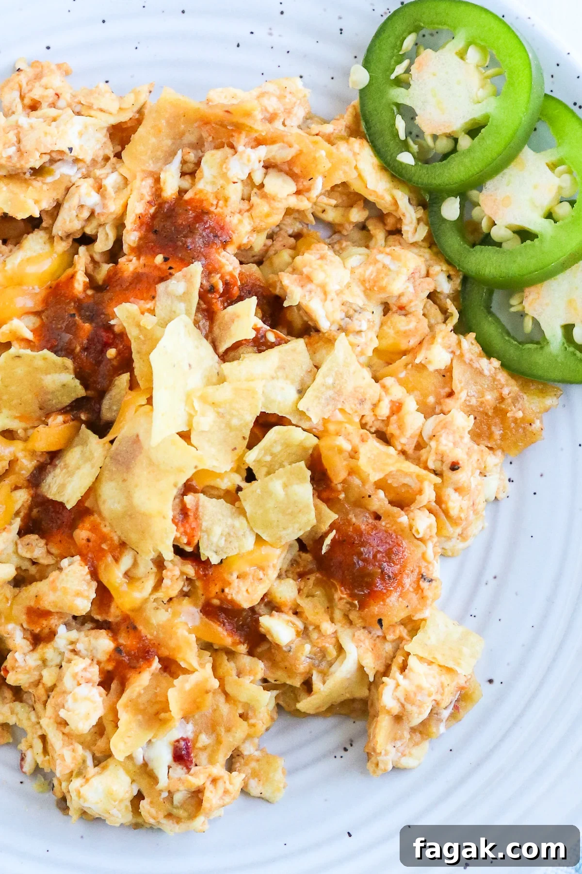 crunched tortilla chips in bite size piece on top of scrambled eggs