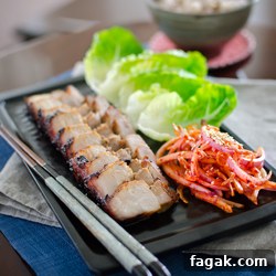 Oven Roasted Korean Pork Belly is served with lettuce and onion salad