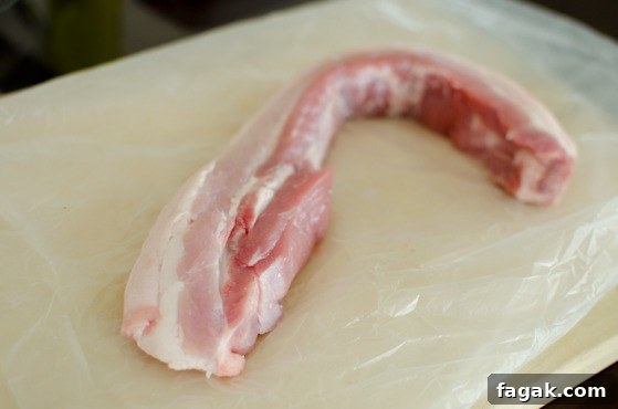 A chunk of pork belly is placed on the board.