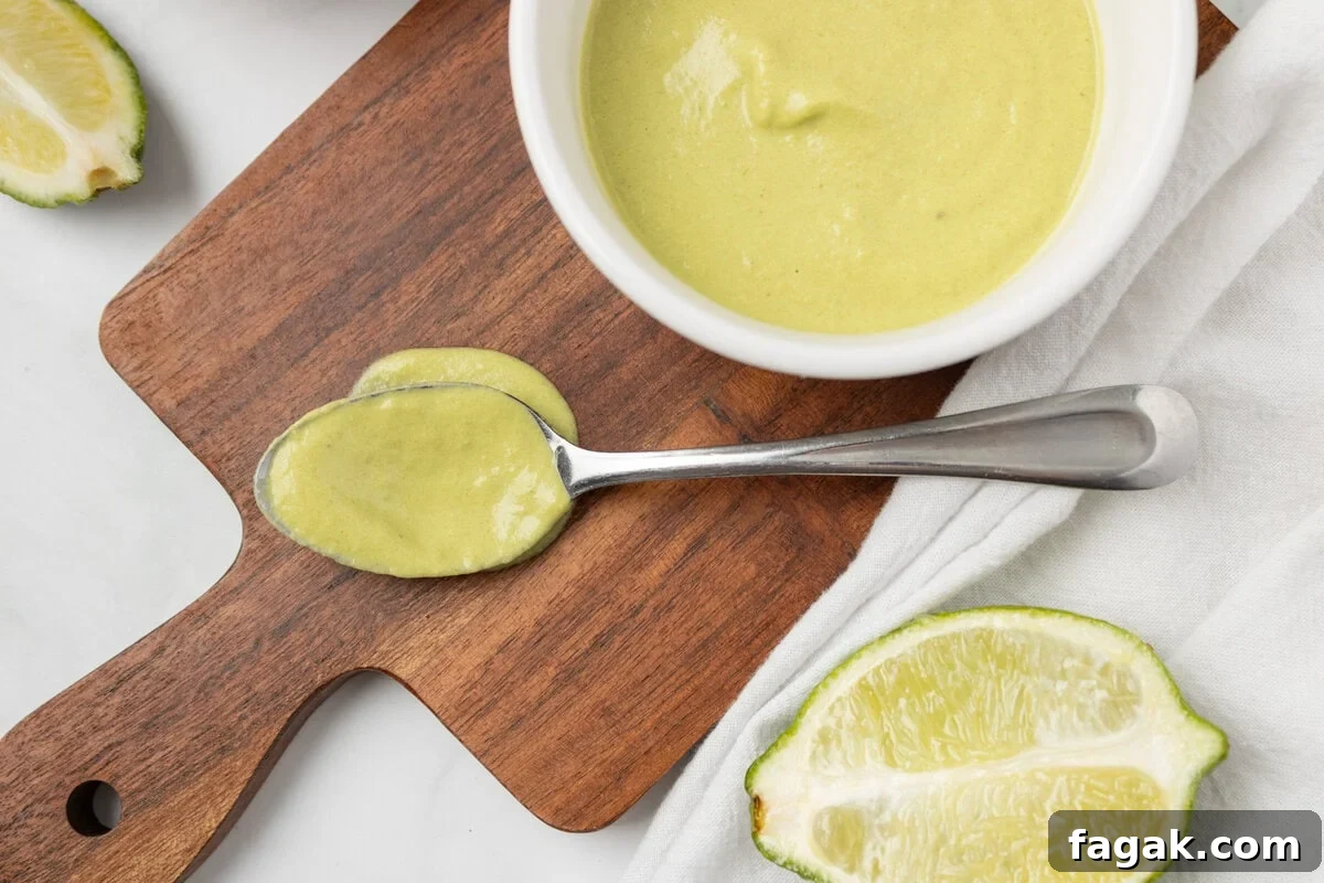 An overhead image of a spoonful of poblano sauce with a bowl of sauce on the side.