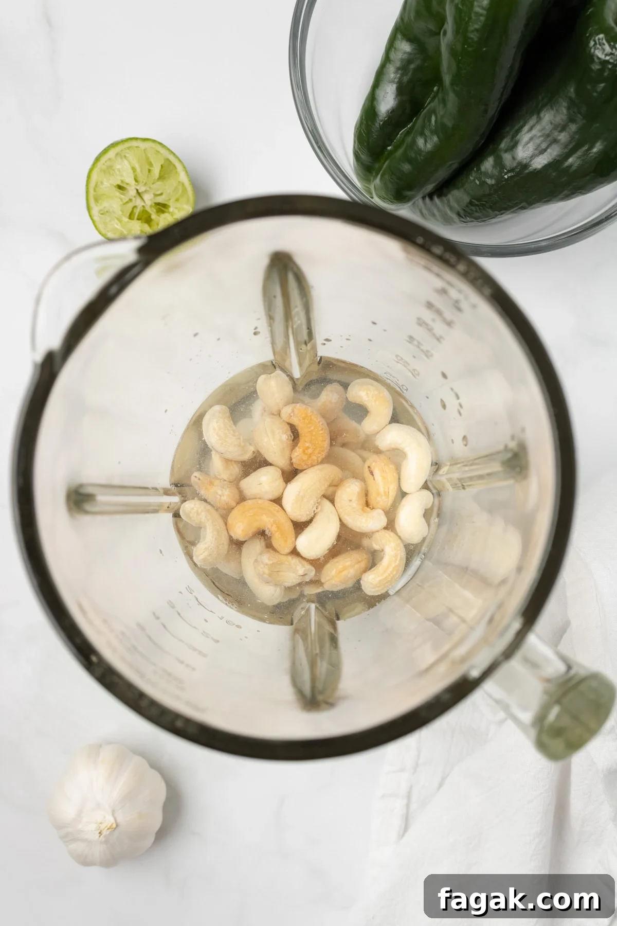 An overhead image of soaking cashews with water in a blender.