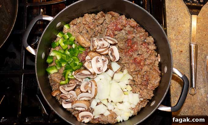 ground sausage, onion, pepper, and mushrooms in a skillet