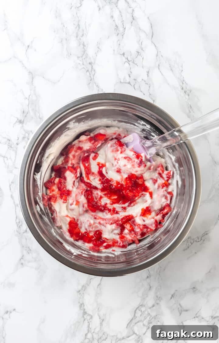 Overhead view of strawberry cream pie filling in mixing bowl