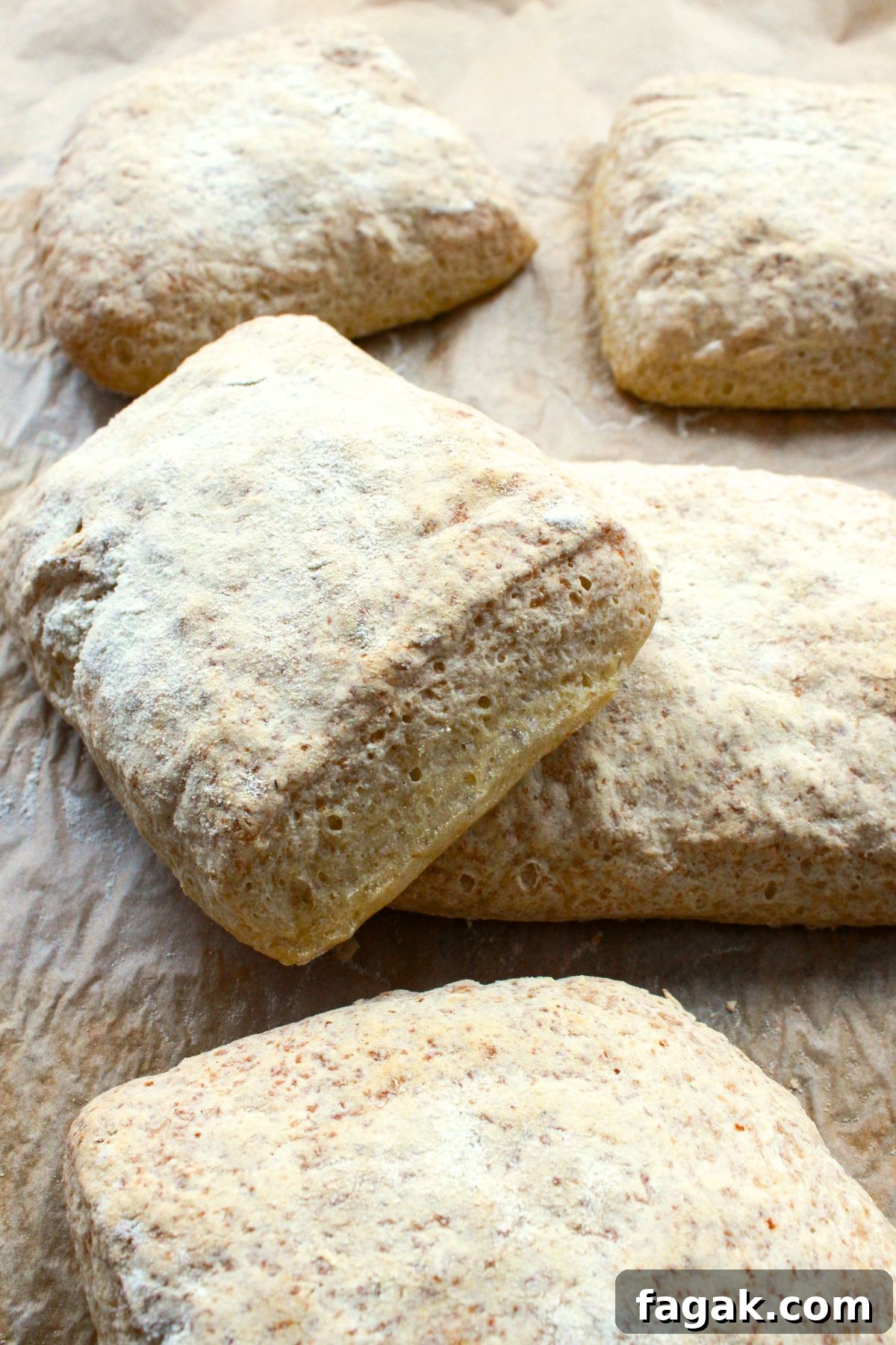 Gluten-free ciabatta rolls on parchment paper.