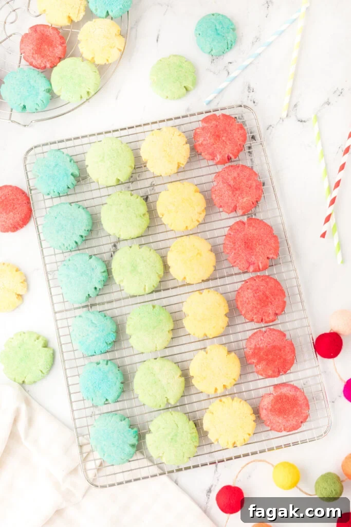 four different colors of jello cookies on cooling rack