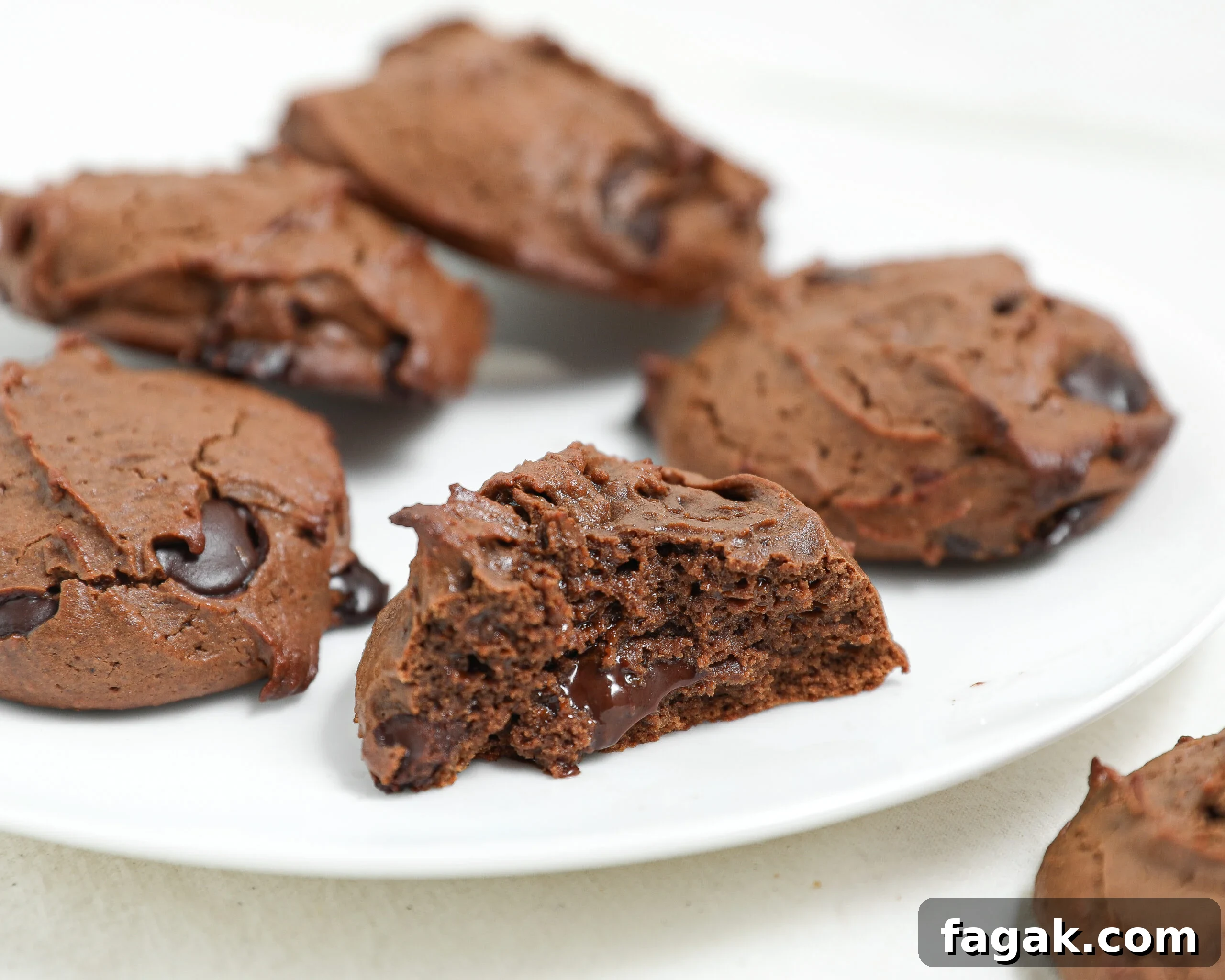 Fudgy protein brownie cookies with melted chocolate chips on a white plate