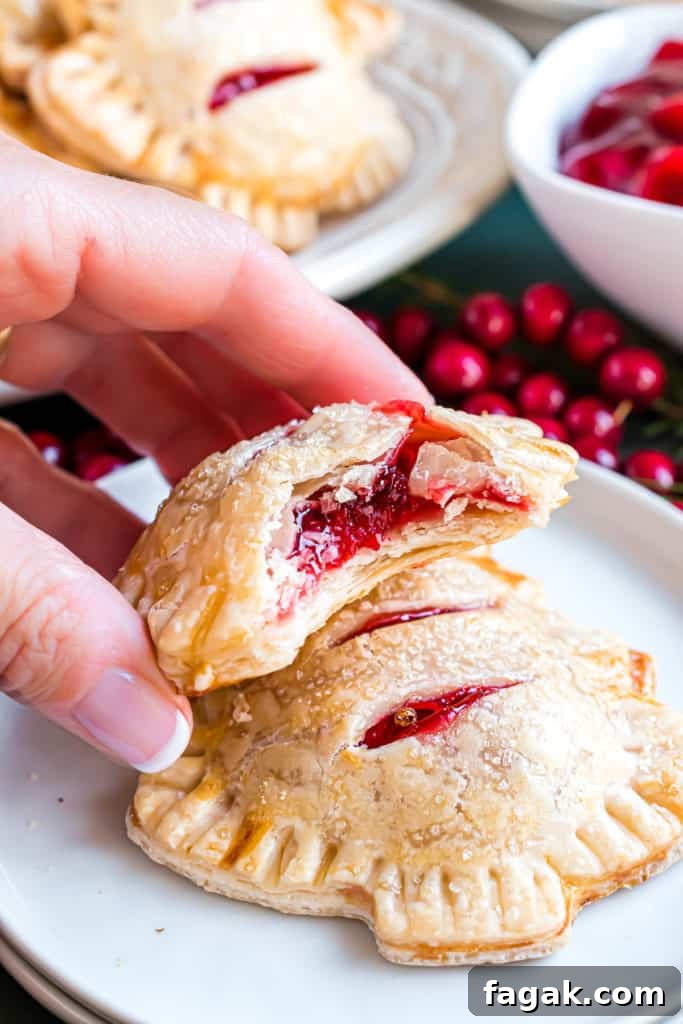 Hand setting a cherry hand pie on a plate.