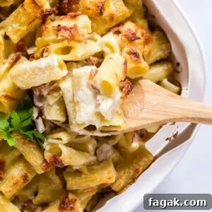 Baking dish of mac and cheese with a wooden spoon in it.