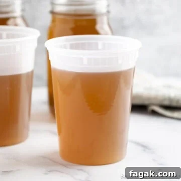 Homemade vegetable stock in a storage containers.