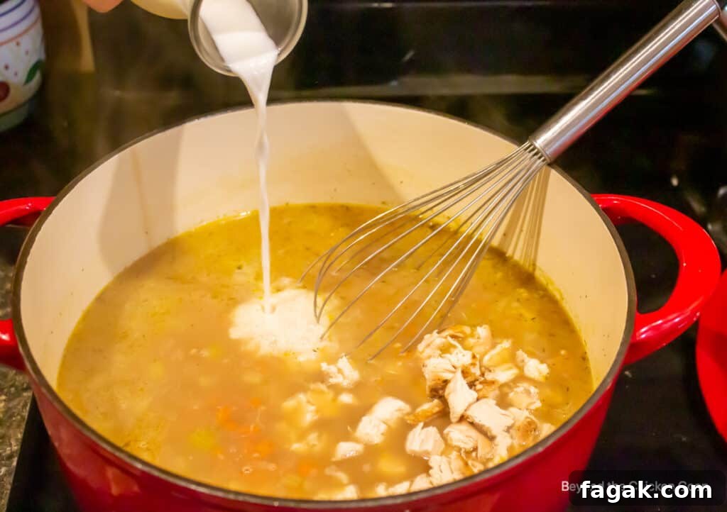 Adding milk to a pot of soup.