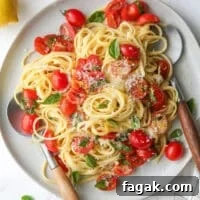 one-pot lemon pasta with tomatoes and basil on a plate in utensils
