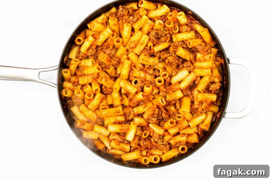 Rigatoni with lamb ragu in a saute pan.