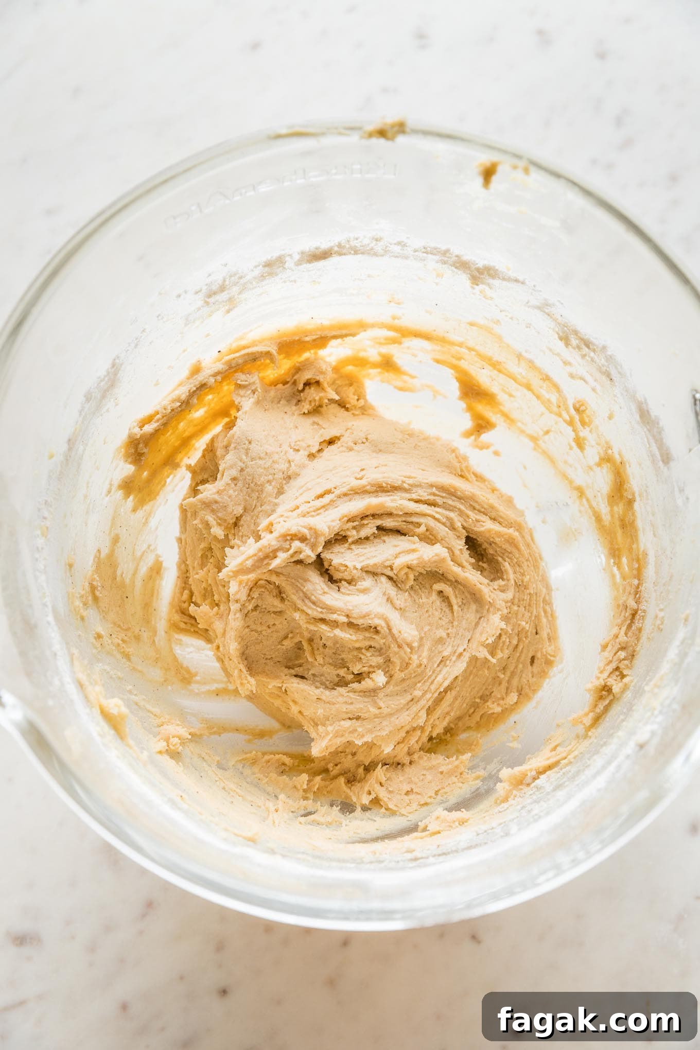 Soft but workable drop sugar cookie dough in a large clear mixing bowl.