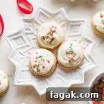 Snowflake plates holding batches of soft frosted eggnog sugar cookies with red and green sprinkles.