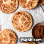 Eggless snickerdoodle cookies with cinnamon on parchment paper.