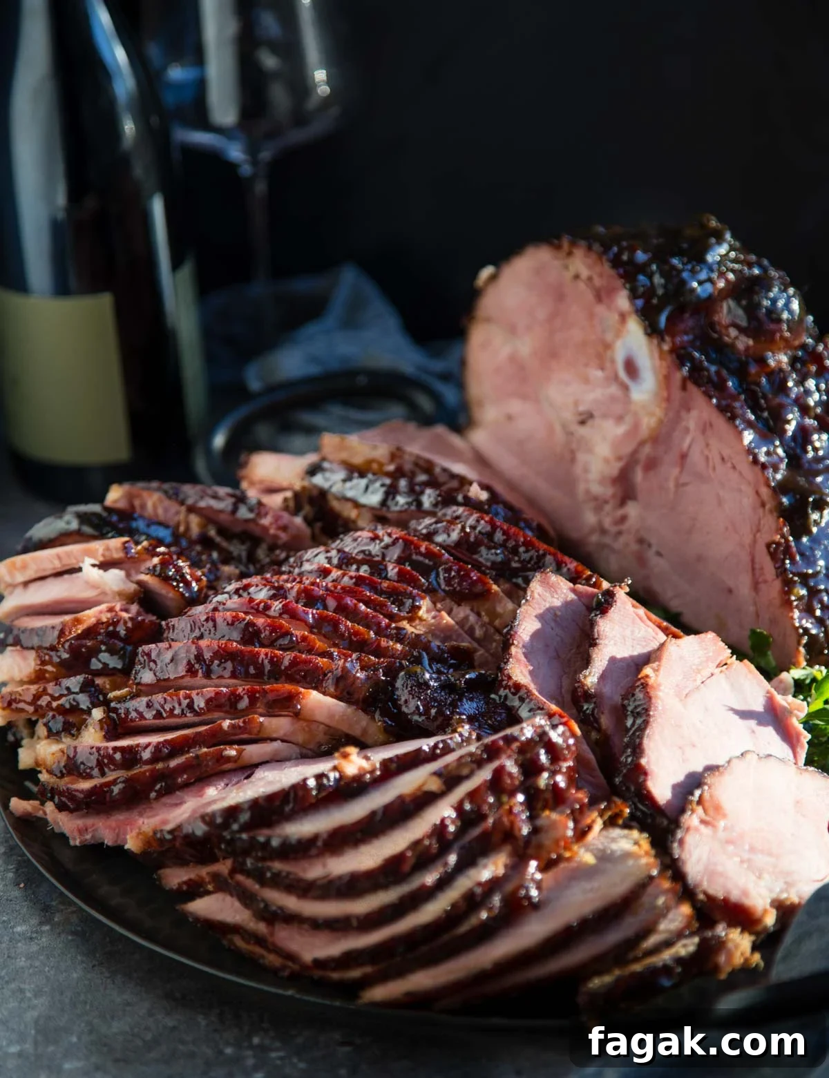 Slices of smoked ham with brown sugar glaze with a bottle of wine