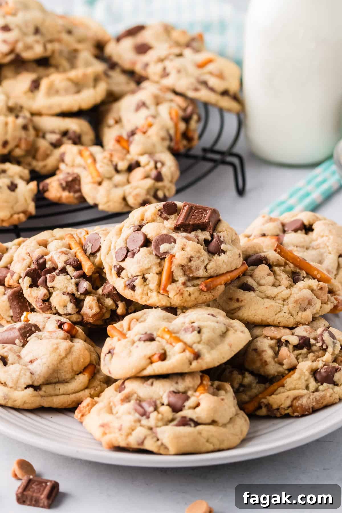 Plate of thick and chunky kitchen sink cookies with milk in the background.
