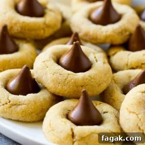A plate with peanut butter blossoms stacked onto it.