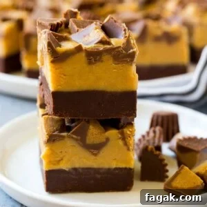 Stacked pieces of chocolate peanut butter fudge on a plate.