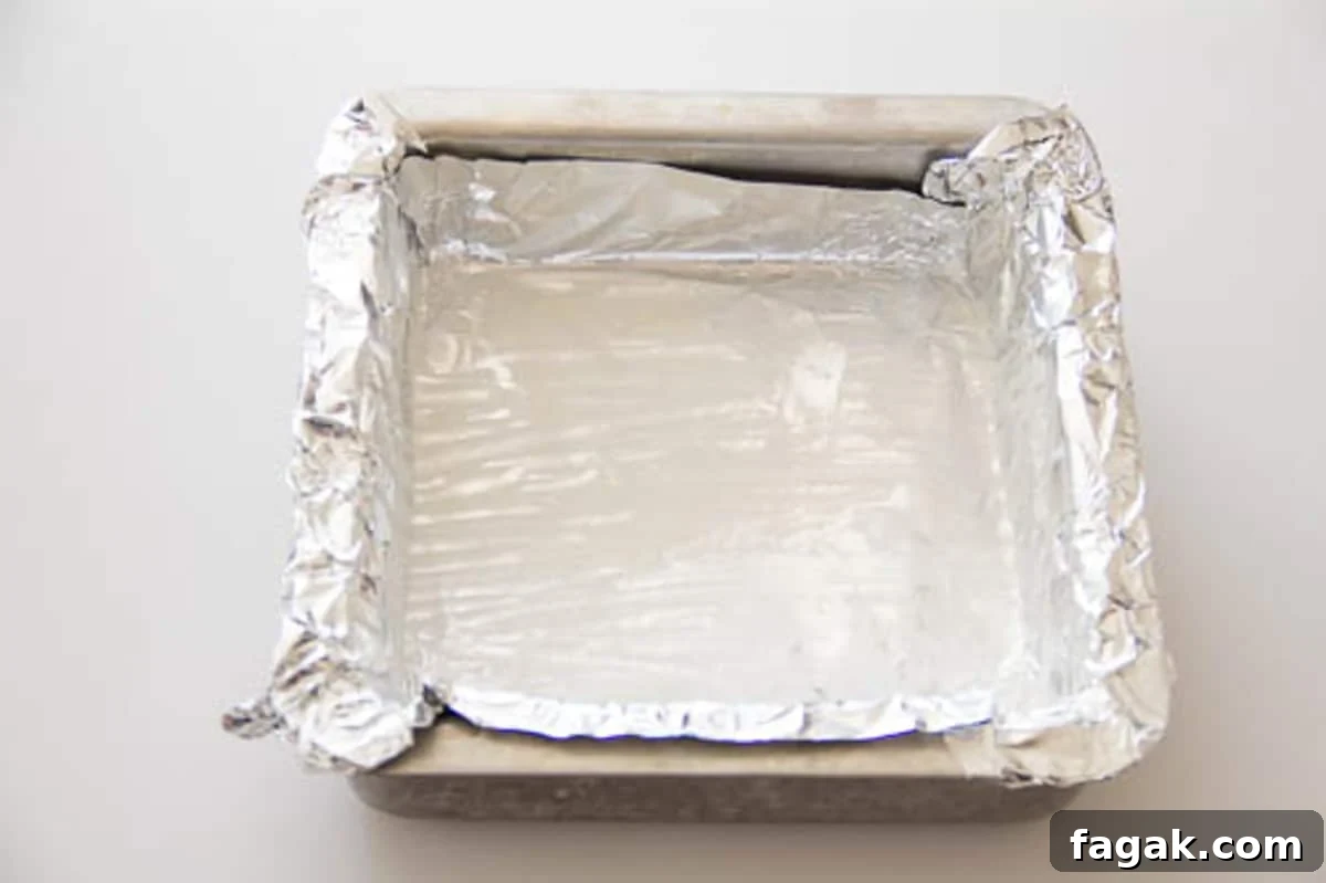 A square baking dish lined with aluminum foil.