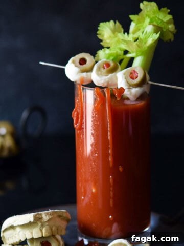 Bloody scary cocktail in a clear glass with cheese eyeballs.