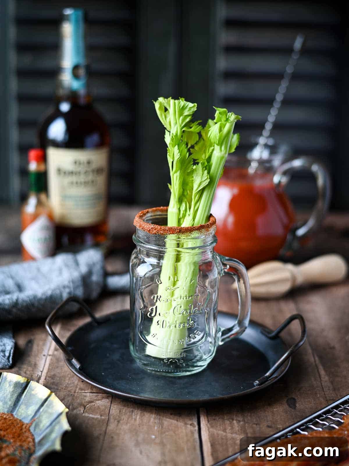 Celery in a Mason glass jar on a wood surface.