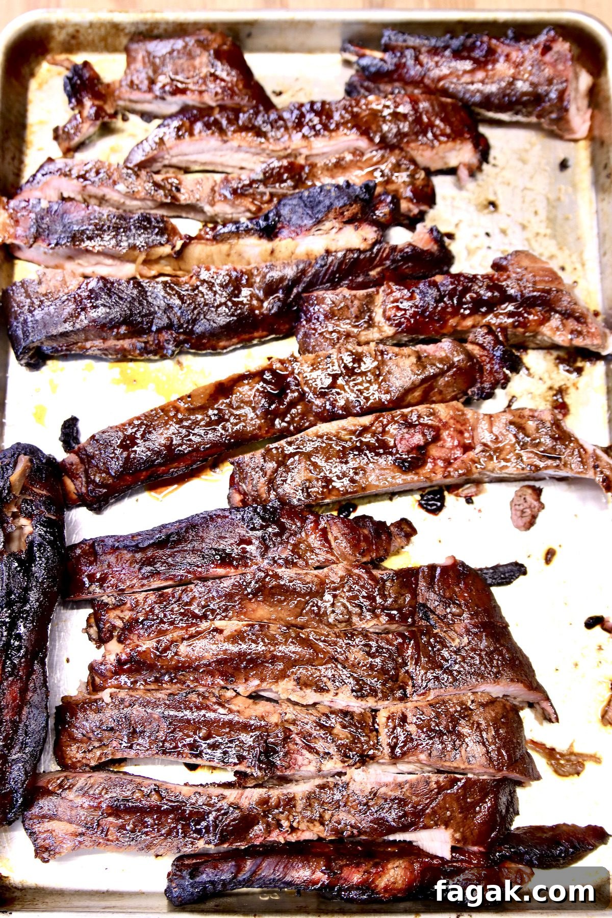 BBQ Spare Ribs with Mop Sauce. baking sheet with sliced, grilled spare ribs.