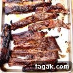 Spare Ribs with Tangy Mop Sauce Recipe 2 sliced ribs on a sheet pan.