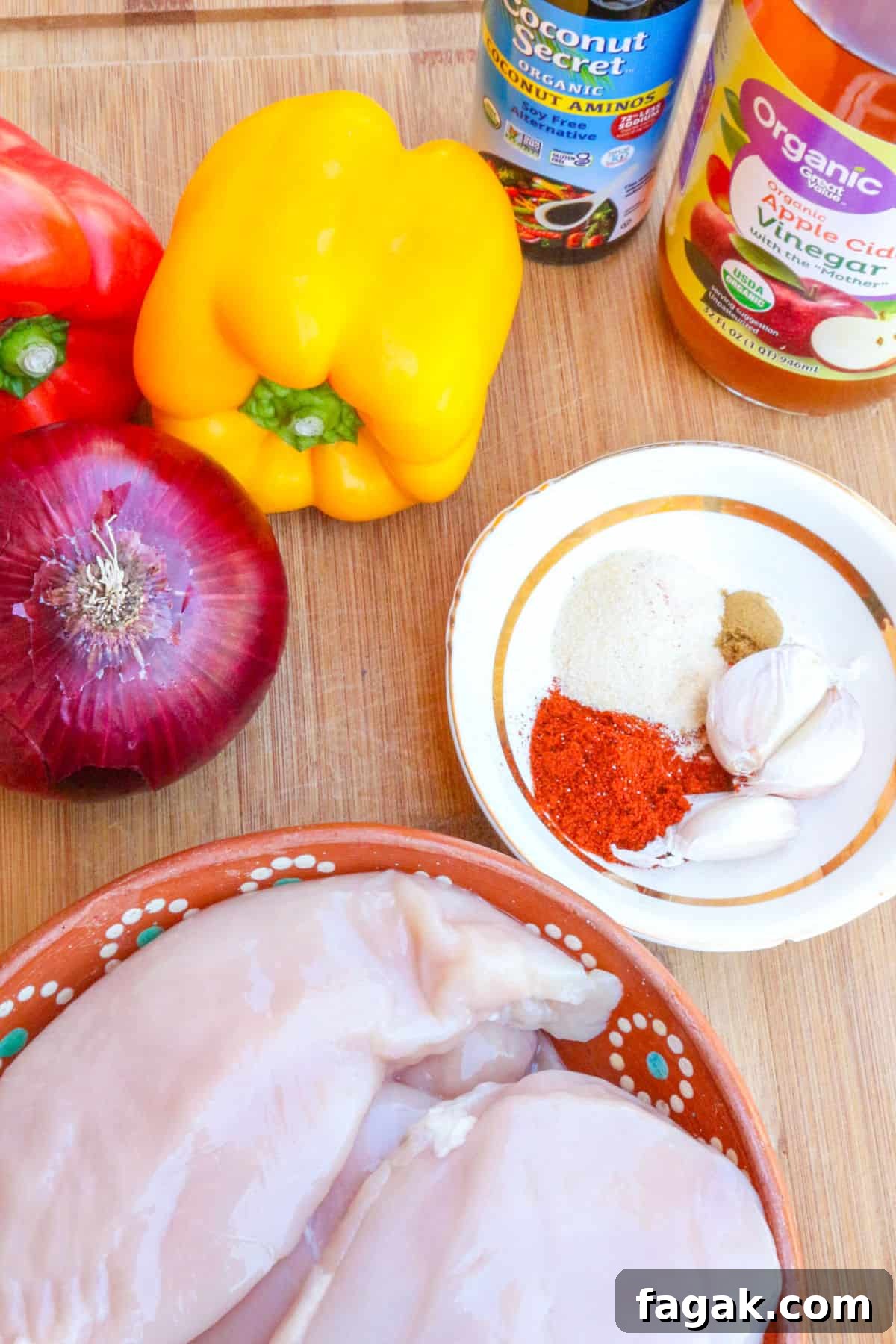 bell peppers, red onion, coconut aminos, apple cider vinegar, spices in a small bowl, chicken breasts