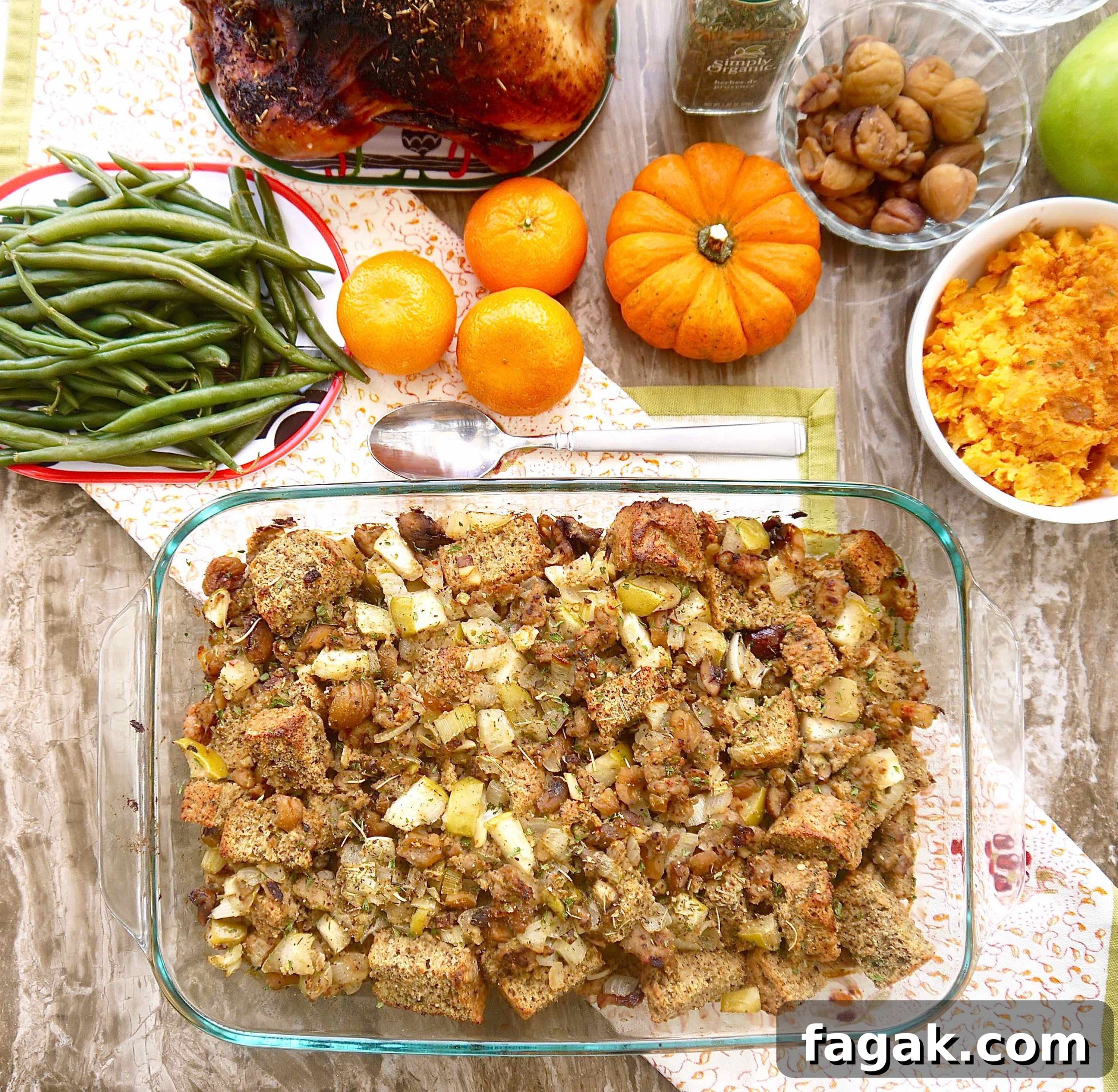 Gluten-free chestnut stuffing with sausage in a large pan, with other sides near it.