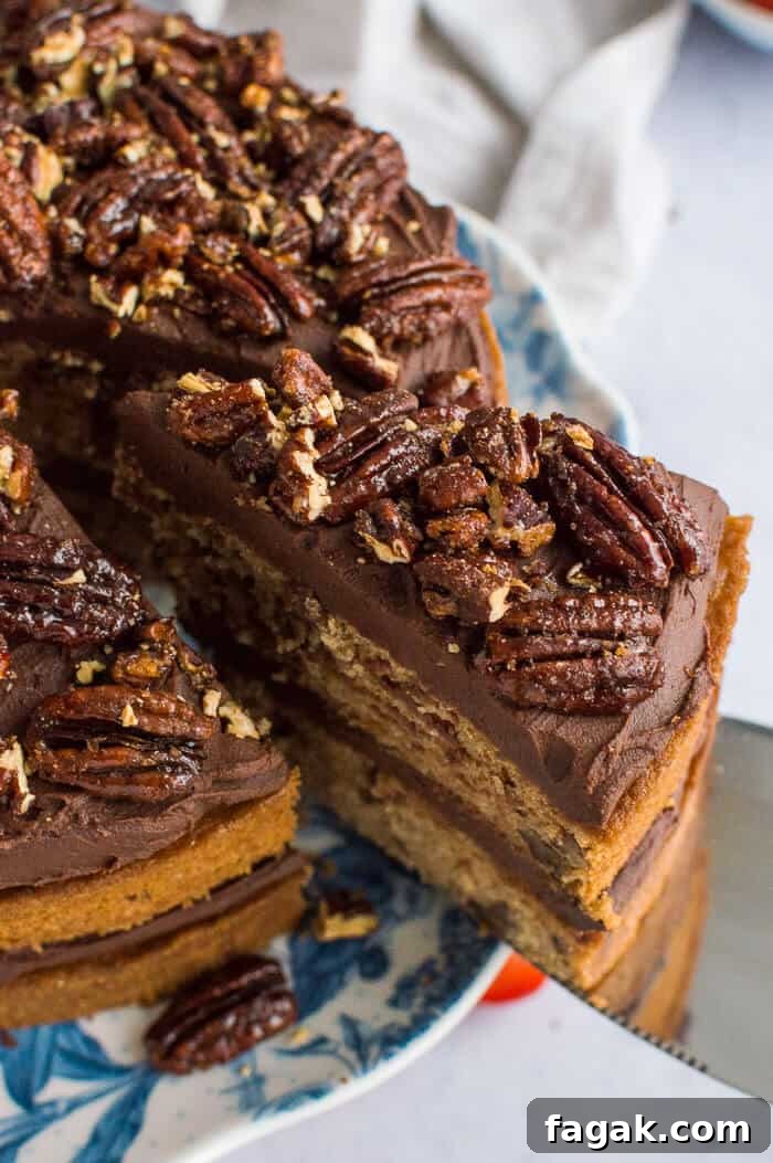 close up of maple pecans on top of vegan maple pecan cake with chocolate cashew cream frosting.