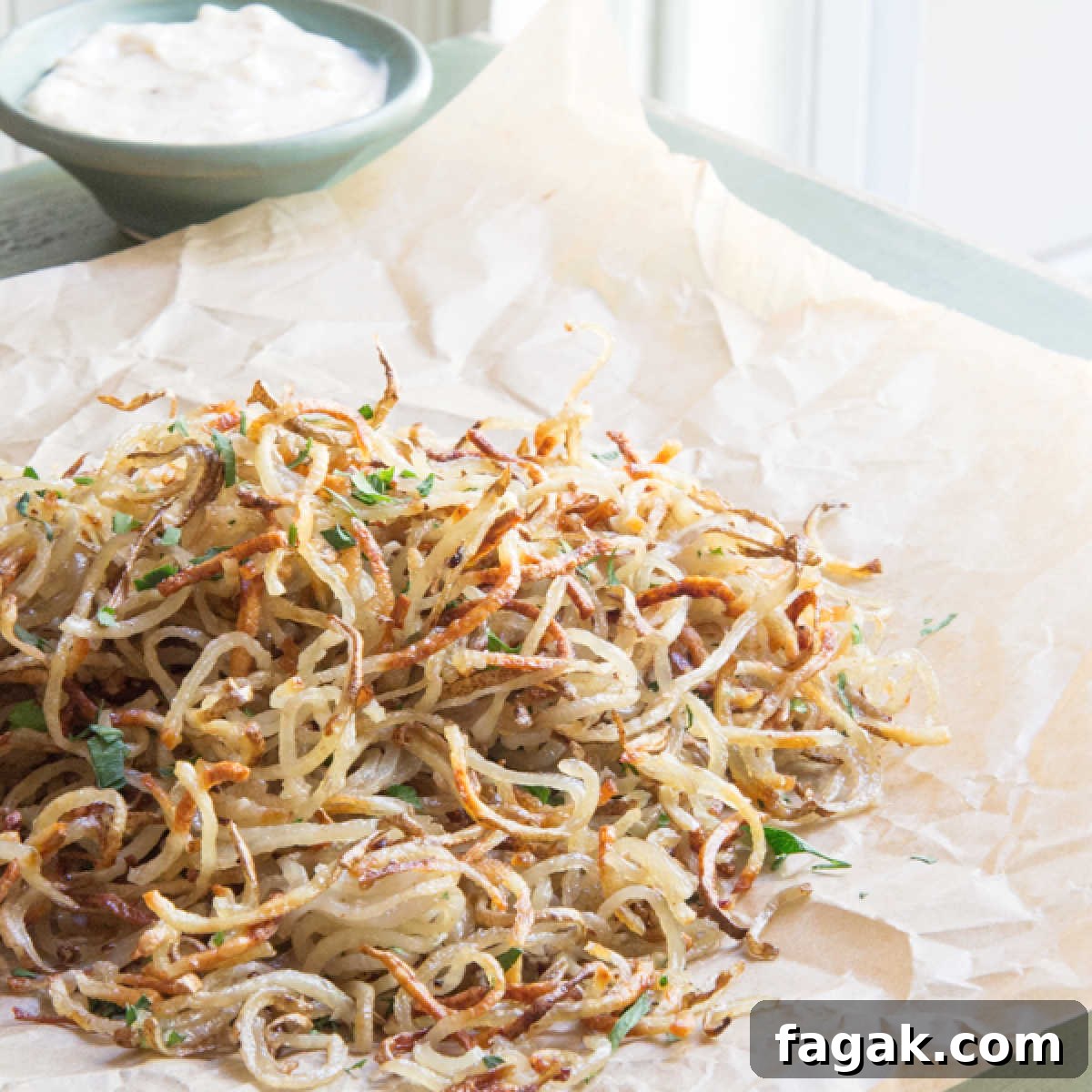 A pile of shoestring truffle potato fries on parchment paper.