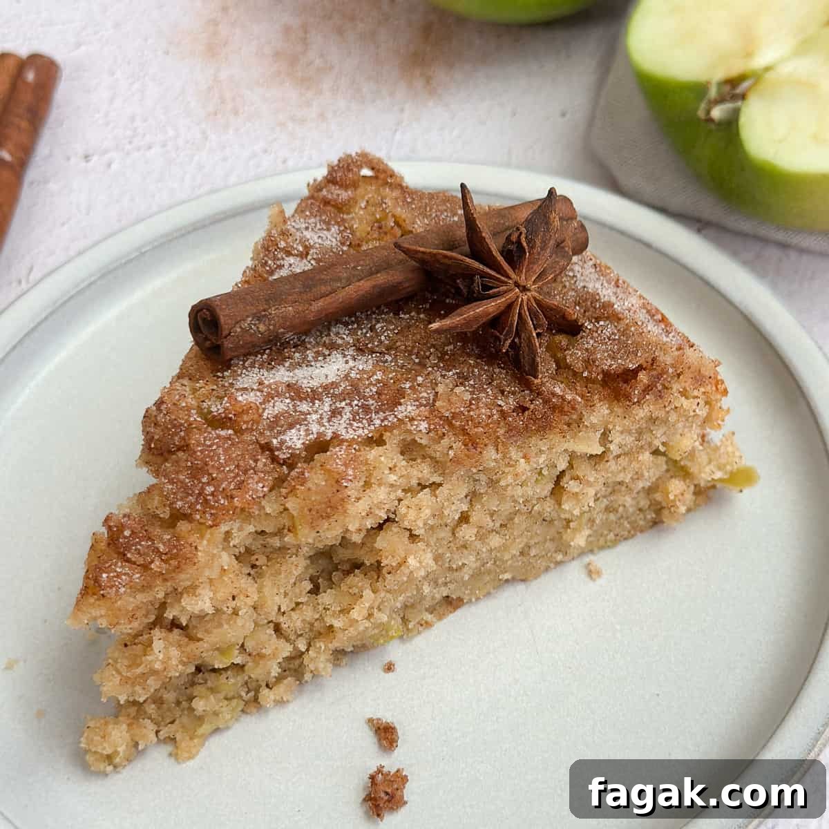 a single piece of cake on a plate topped with a cinnamon stick.