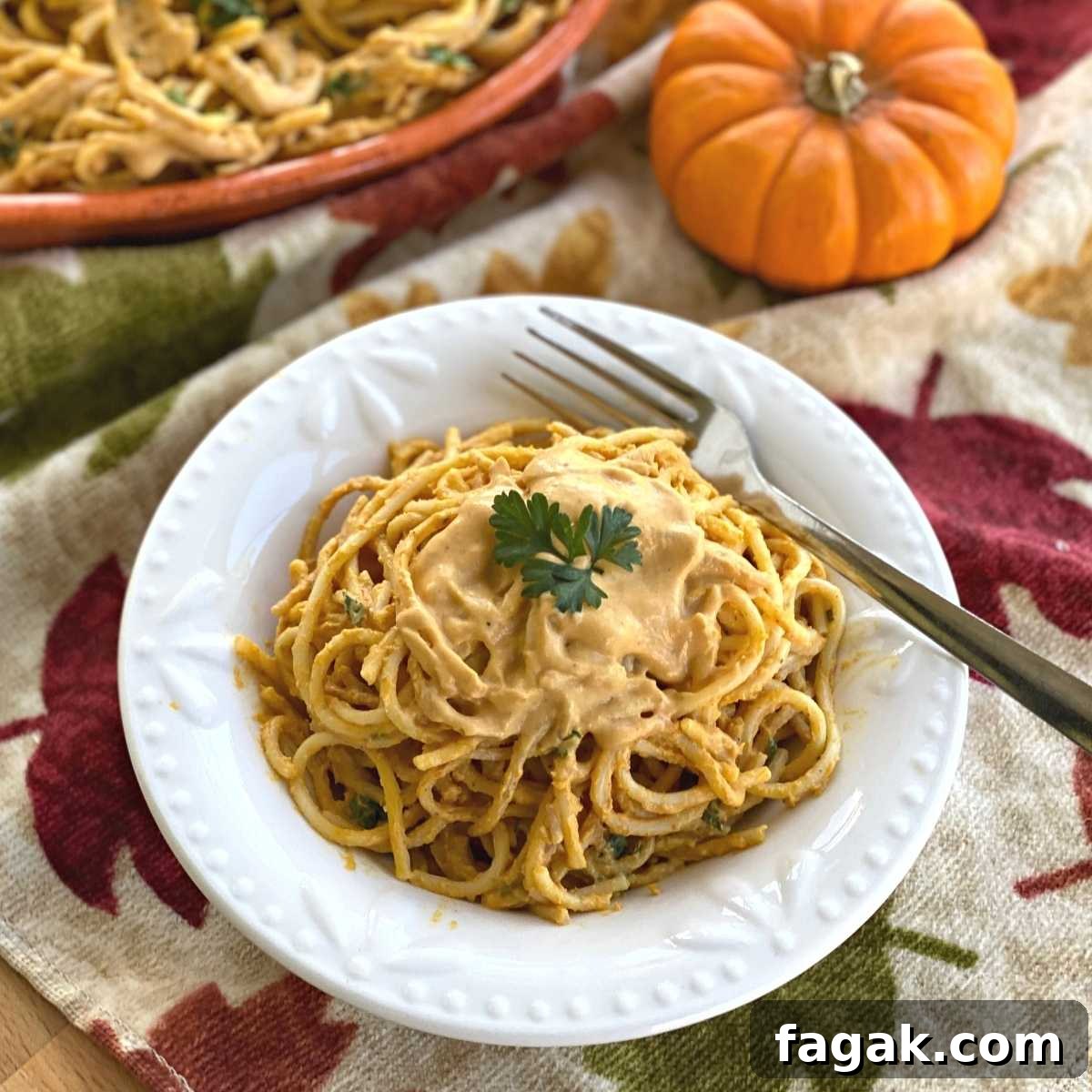Bowl with creamy pumpkin pasta sauce over spaghetti noodles.