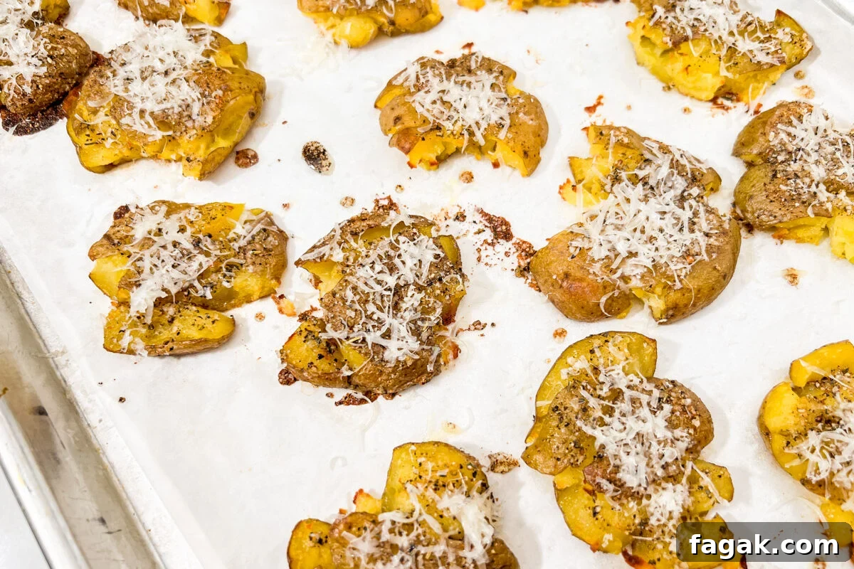 Golden smashed potatoes fresh from the oven with melted parmesan on top.
