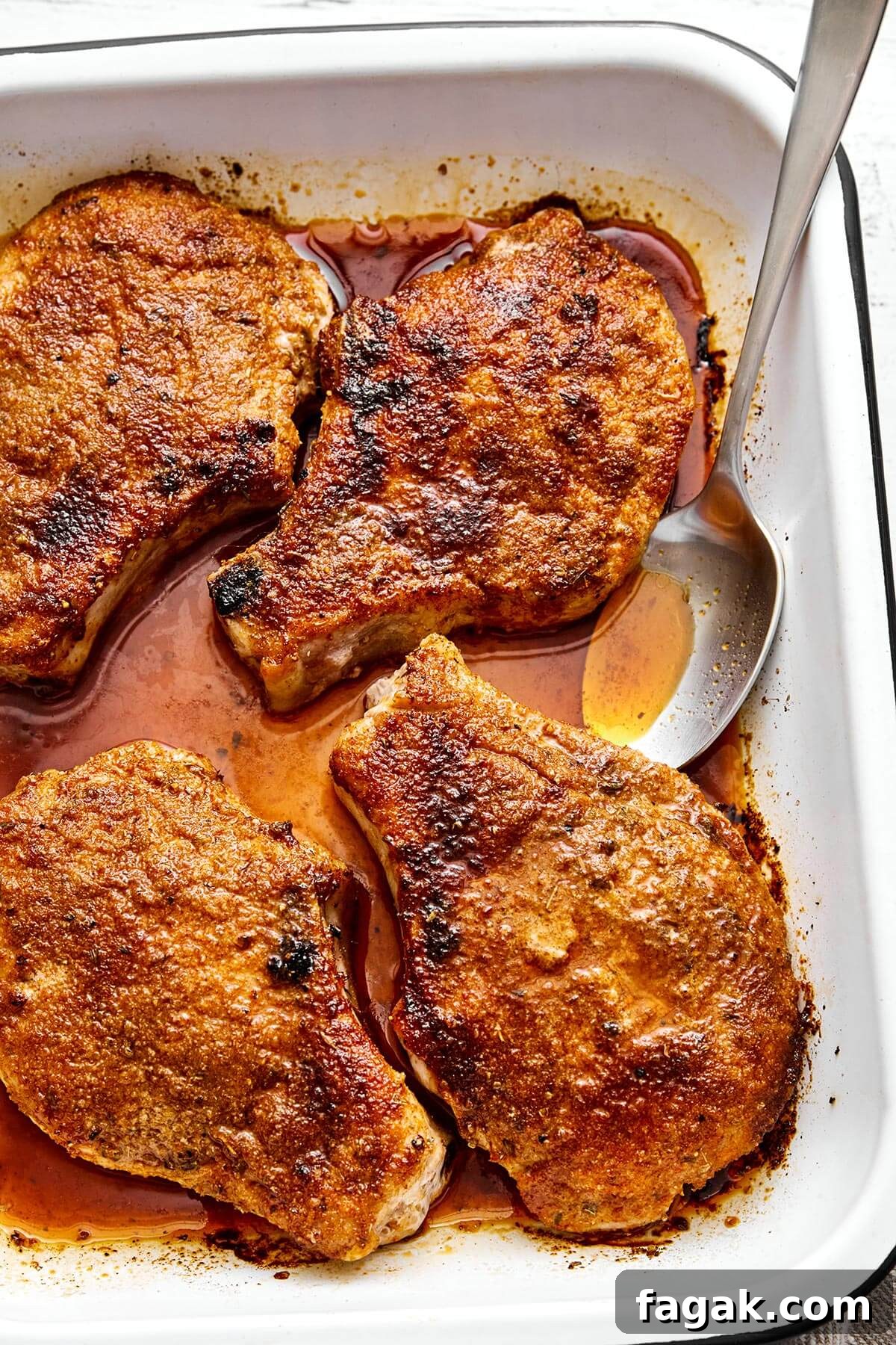 Baked pork chops in a baking dish.