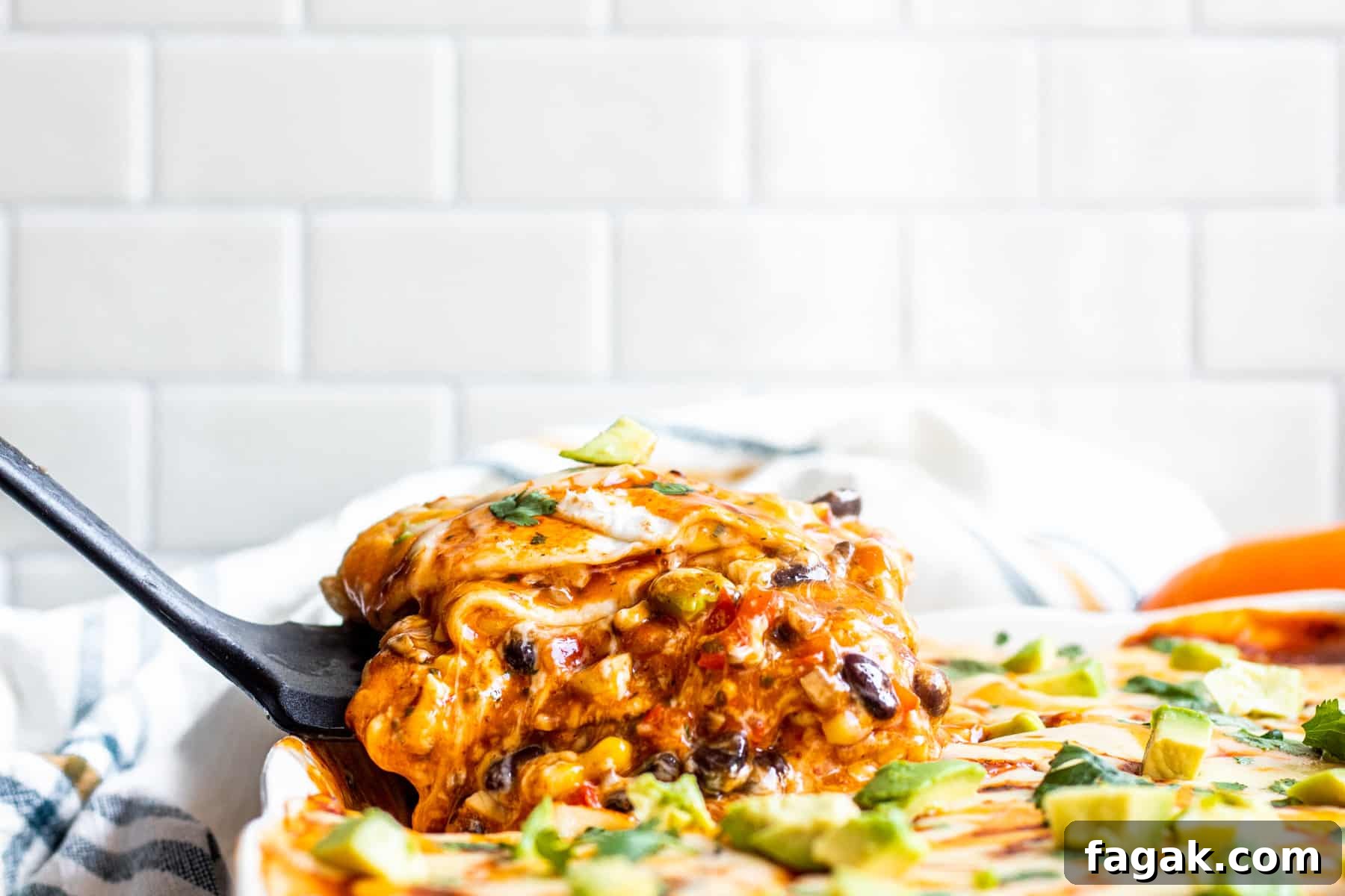 Spatula scooping out taco casserole of baking dish.