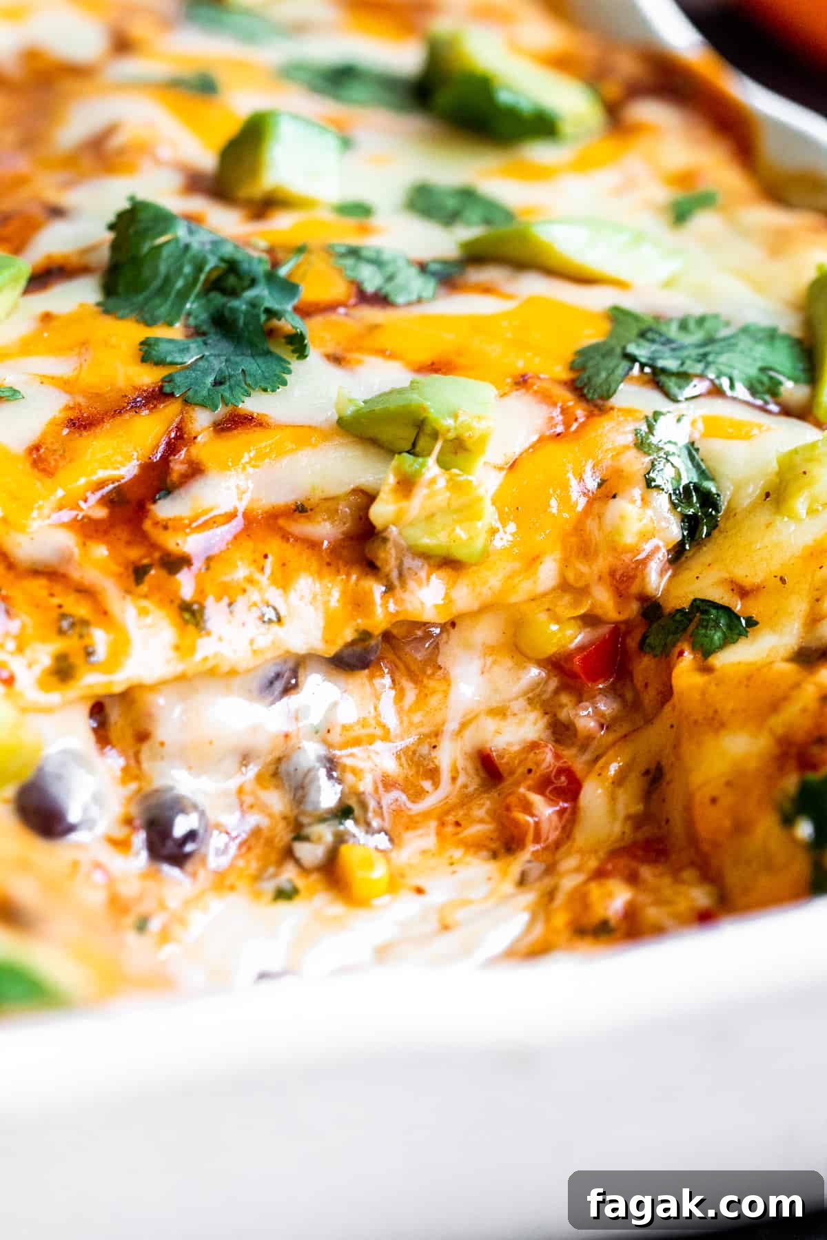 Lasagna with scoop taken out of white baking dish.