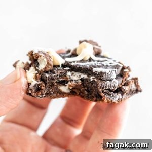 hand holding one of the cookies and cream cookie bars missing a bite