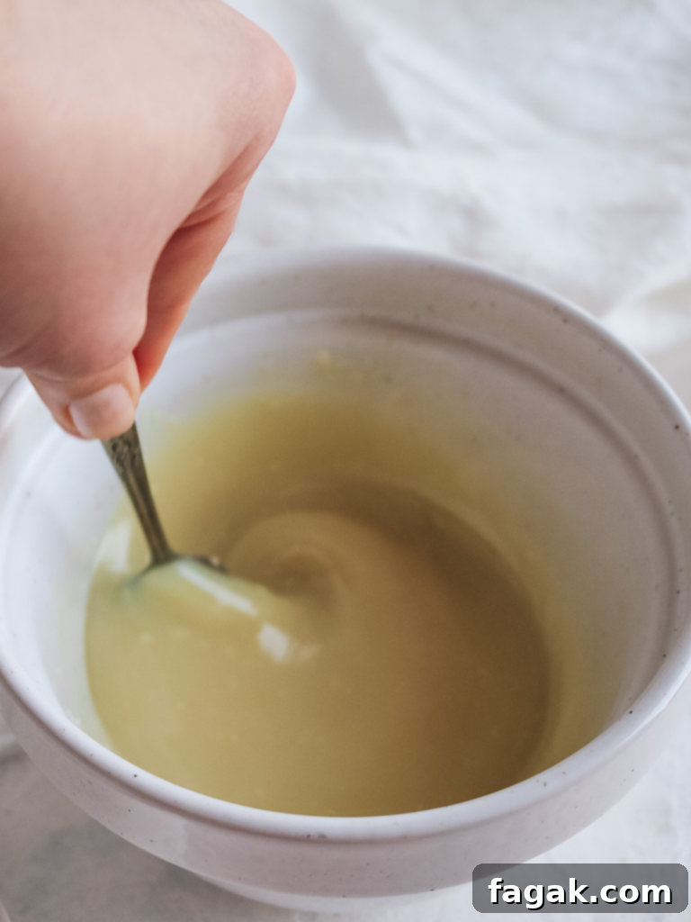 whisking melted white chocolate chips and cream together to make white chocolate ganache.