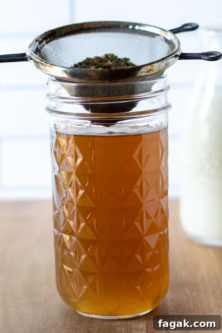 Straining lavender syrup into jar.