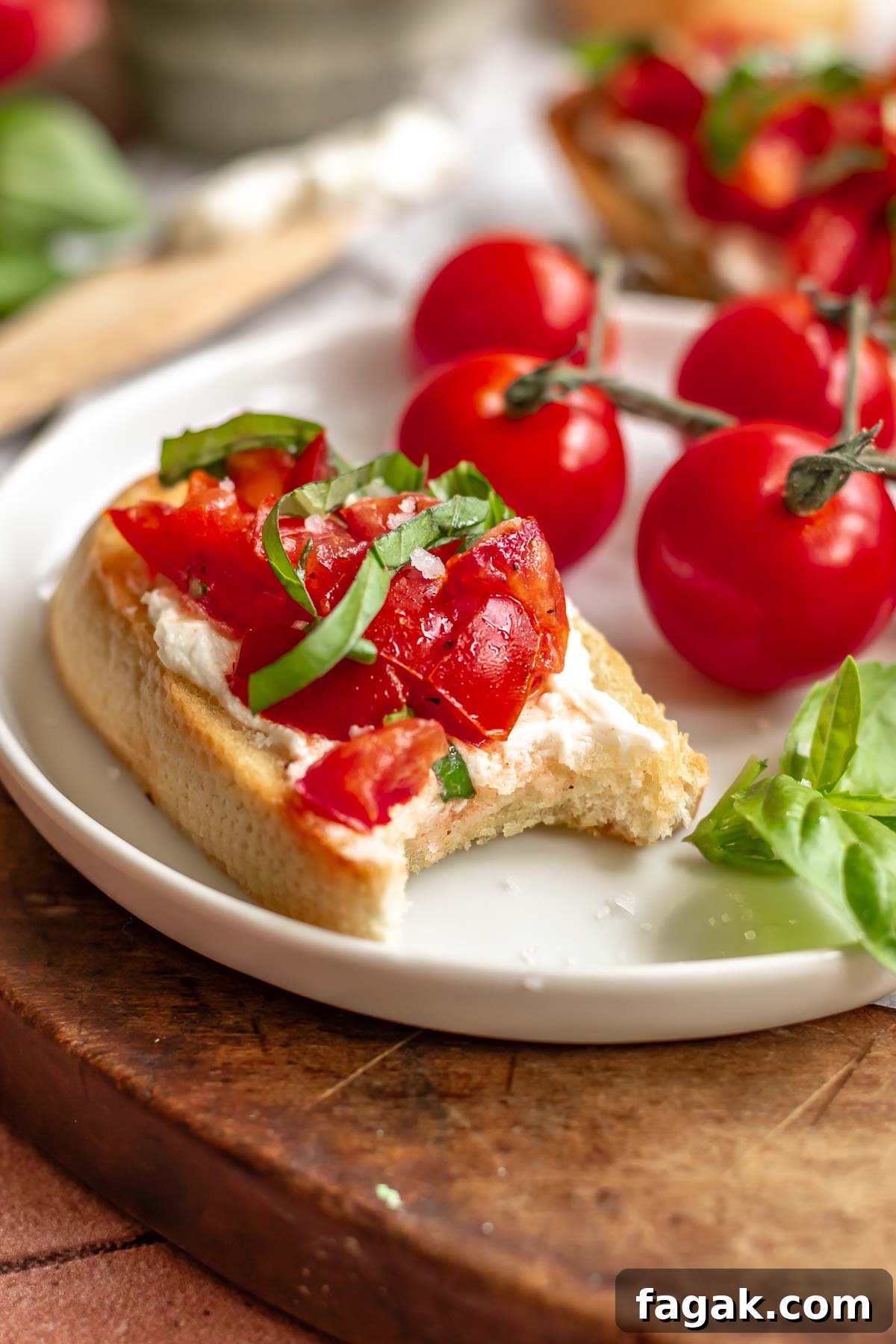Bruschetta on a plate with a bite removed.