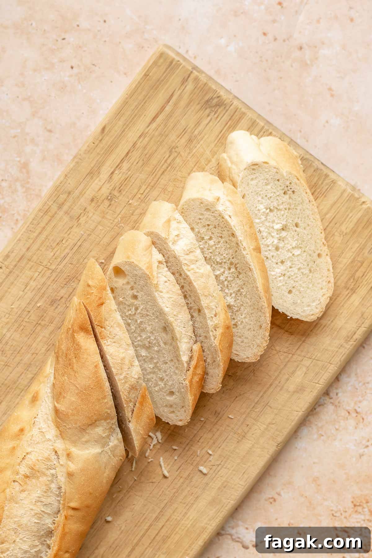 Bread sliced on the bias on a cutting board.