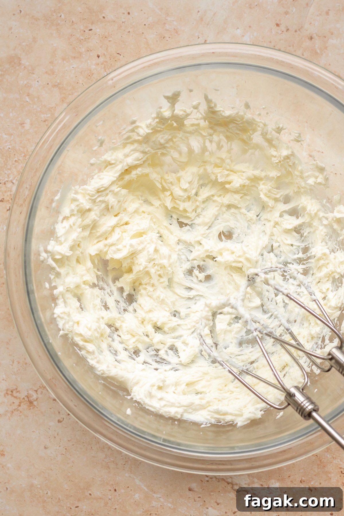 Whipped goat cheese in a bowl with beaters on the side.
