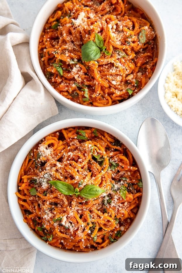 overhead shot of two Italian sweet potato noodle bowls sprinkled with basil and parmesan cheese