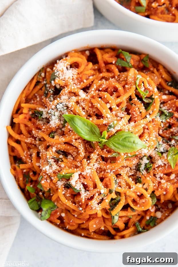 overhead shot of an Italian sweet potato noodle bowl with parmesan cheese and fresh basil 
