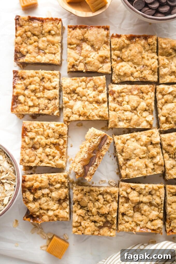 Just-cut squares of carmelita bars laid out on white parchment paper.