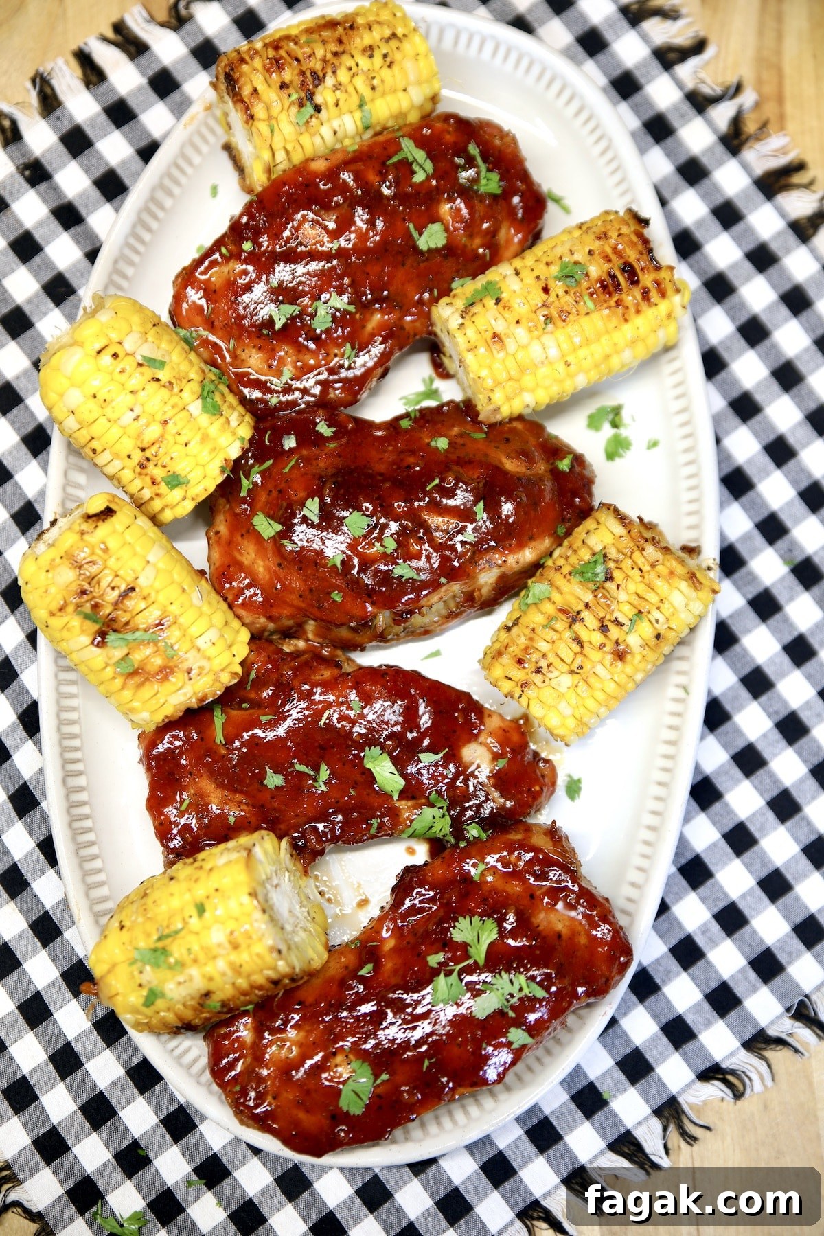 Platter of bbq pork chops and corn on the cob.